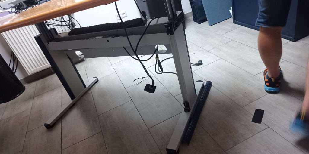 Defekter Schreibtisch mit herunterhängenden Kabeln